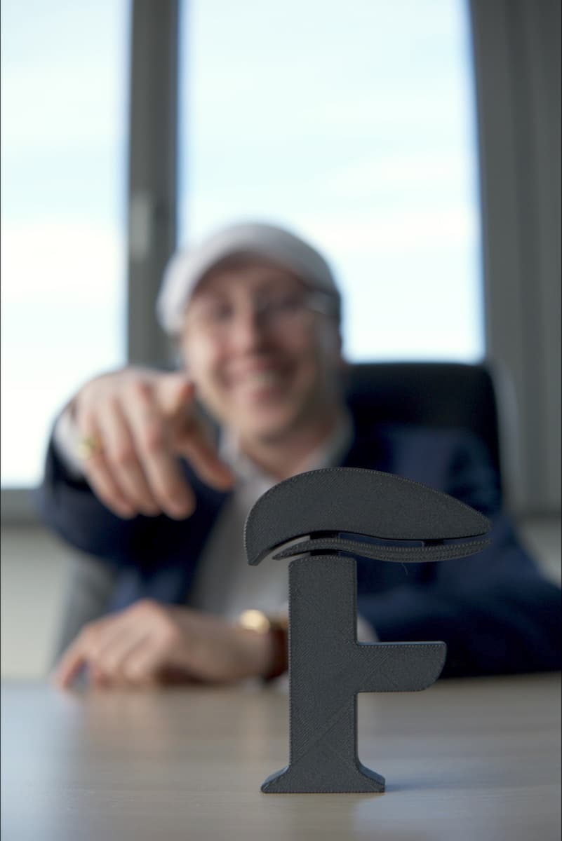 The FINANZLAU brand mark as a 3D-printed desk piece